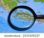 Magnifying glass close up with Map of Jakarta. DKI Jakarta is the capital city of Indonesia, located in the northwestern part of the island of Java.