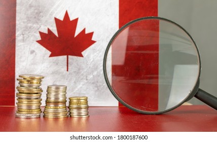 Magnifying Glass And Coins In Front Of Canada Flag, Country Economy Concept