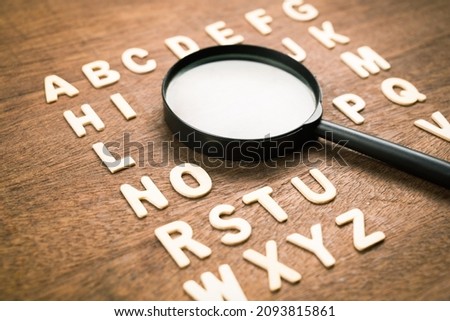 Magnifying glass in English alphabetical order from A-Z wood letters, learning English language, vocabulary and glossary, find the right word to communicate