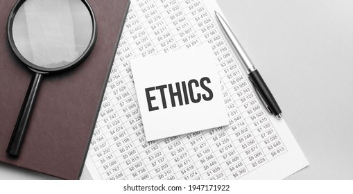 Magnifying Glass, Financial Document, White Paper Sheet Witn ETHICS Sign And Brown Notebook On Grey Background.
