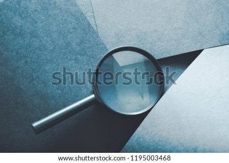 magnifying glass. finding things or detecting problems concept. loupe on layered blue paper background.