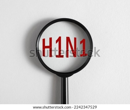 Magnifying glass focused on text H1N1 influenza virus serotype A, swine flu.