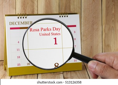 Magnifying glass in hand on calendar you can look text Rosa Parks Day of United States in Ohio and Oregon,concept of a public relations and campaign.
