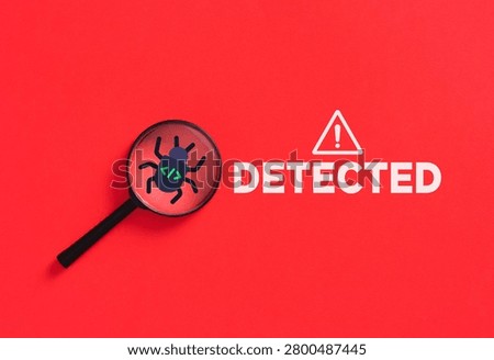 Magnifying glass highlighting a program software bug icon with code syntax on a red background with a detected warning message