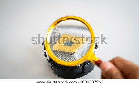 Magnifying glass inspecting computer processor on CPU cooler, highlighting semiconductor technology, hardware analysis and microelectronics. Concept of artificial intelligence, quality control and digital innovation.
