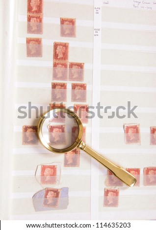 Magnifying glass laying on a philatelic stamp album