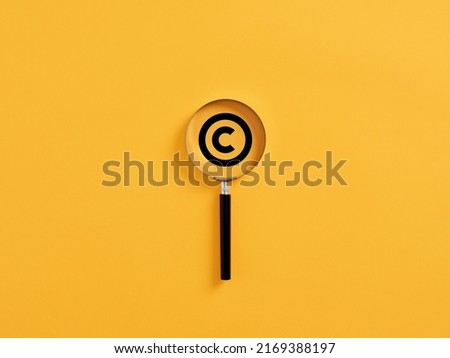 Magnifying glass magnifies copyright symbol. Concept of patenting or copyright protection.