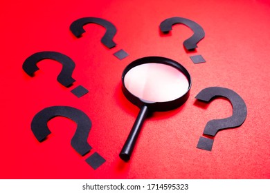 Magnifying Glass With Many Qustion Mark Symbol On Red Paper Background