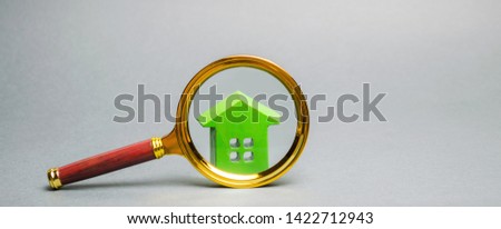 Magnifying glass and miniature wooden house. House searching concept. Home appraisal. Property valuation. Choice of location for the construction. Search for housing and apartments. Real estate
