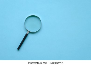 Magnifying Glass On Blue Background. Copy Space. Top View.