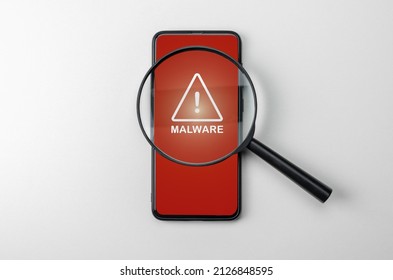 Magnifying Glass On Cell Phone, An Alarm Sign Detecting Malware. Virus Malware Under Magnifying Glass, Anti-virus Finds Malicious App. Search For Malware