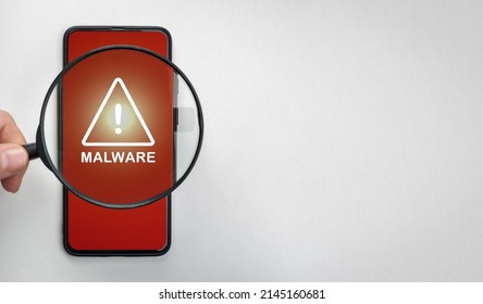 Magnifying Glass On Cell Phone, An Alarm Sign Detecting Malware. Mobile Phone Security Concept. Virus Alert. Search For Malware. White Background, Copy Space