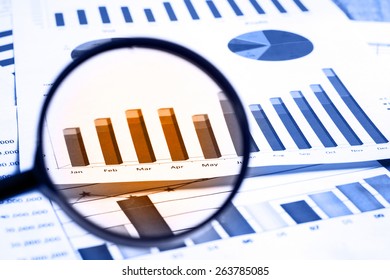 magnifying glass on financial report documents 