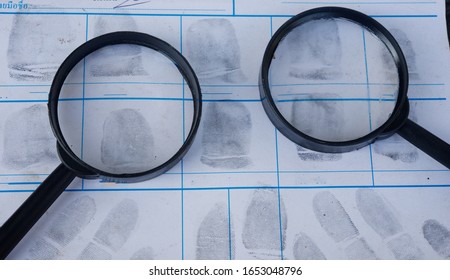 Magnifying glass on fingerprint crime page file.Concept of finding evidence in criminal.