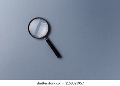 Magnifying Glass On Grey Background. Top View. Flat Lay. Copy Space. Concept