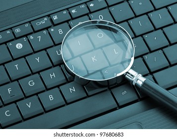 Magnifying Glass On Laptop Computer. Toned In Blue