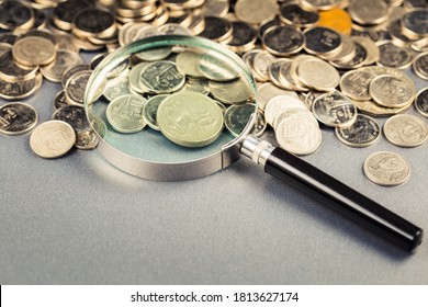 Magnifying Glass On The Pile Of Money Coins On The Table, Financial Status, Economic Analysis