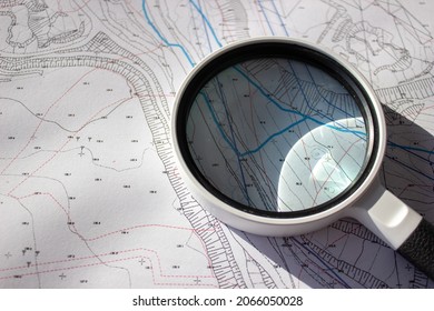 A magnifying glass on a planning basemap - Shutterstock ID 2066050028