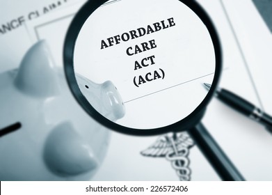 Magnifying Glass Over Affordable Care Act Policy And Piggy Bank