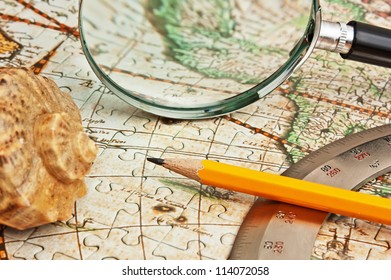 magnifying glass and a pencil on a map