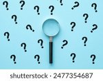 Magnifying glass and question mark signs on blue background. Searching for information, data, solution or answer.
