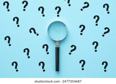 Magnifying glass and question mark signs on blue background. Searching for information, data, solution or answer.