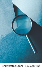 magnifying glass. science research exploration and scrutiny concept. loupe on layered blue paper background. - Shutterstock ID 1195003462