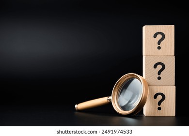 Magnifying glass and stack of question mark wood cubes, analyze the questions, FAQs, and questions that need the answer 
