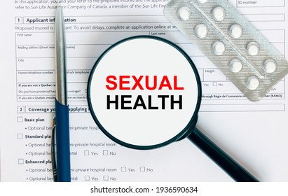 Magnifying Glass With Text Sexual Health Inside Lies On Medical Documents With Pills And A Blue Metal Pen. Can Be Use As A Concept Photo