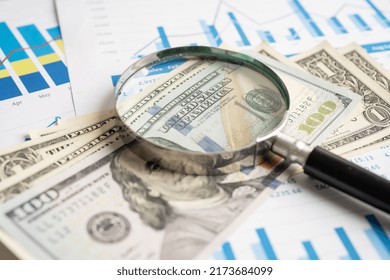 Magnifying Glass With US Dollar Banknotes On Charts Graphs Paper. Financial Development, Banking Account, Statistics, Investment Analytic Research Data Economy.