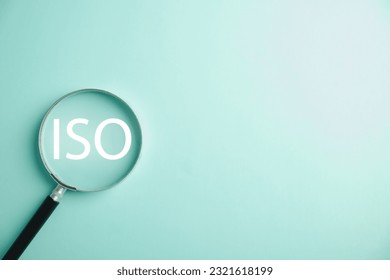 A magnifying glass is used to magnify the word ISO, highlighting its importance in standardization and security control. efforts of professionals in using technology and adhering to ISO 9001 standards
