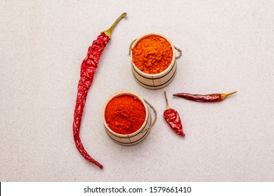 Magyar (Hungarian) red sweet and hot paprika powder. Traditional seasoning for cooking national food, different varieties of dry pepper. Wooden kegs, stone background, copy space, top view, close up