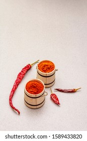 Magyar (Hungarian) red sweet and hot paprika powder. Traditional seasoning for cooking national food, different varieties of dry pepper. Wooden kegs, stone concrete background, copy space