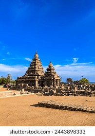 Mahabalipuram temple under blue sky with the beach behind
