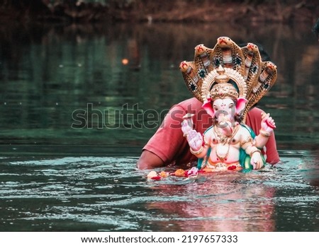 Maharashtra, India.Visarjan of Ganesha idol with five headed snake.