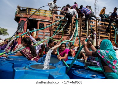 MAHARASHTRA/INDIA - MAY 16, 2016 : Residents climb on municipal water tanker to fill their containers in Beed.