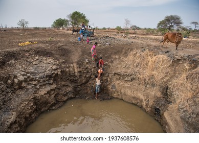 MAHARASHTRA-INDIA-MAY 17, 2016: Villagers collecting water at the bottom of a well in drought prone Beed district.