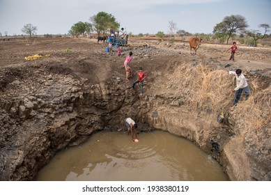 MAHARASHTRA-INDIA-MAY 17, 2016: Villagers collecting water at the bottom of a well in drought prone Beed district.