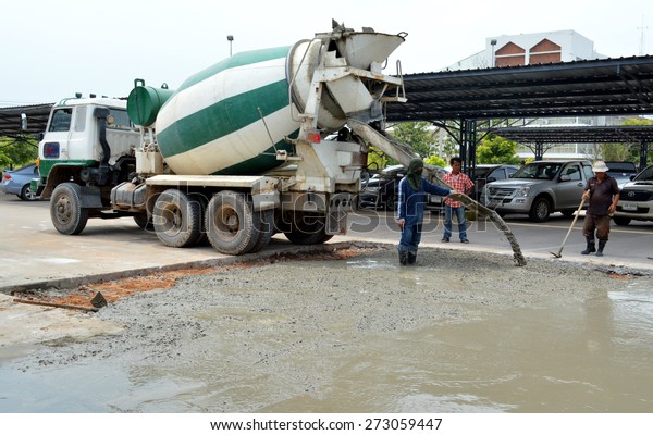 MAHASARAKHAM - OCTOBER 8 : Masonry workers\
repair concrete parking floor at Sermthai complex on October 8,\
2014 in Mahasarakham,\
Thailand.