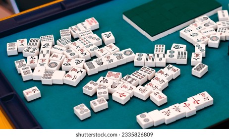 A mahjong table with an active game. An ancient Asian game called Mahjong as a way to relax and have fun.