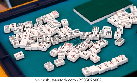 A mahjong table with an active game. An ancient Asian game called Mahjong as a way to relax and have fun.