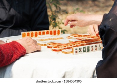 Mahjong Table Gambling Game Of Chinese Senior On City Street
