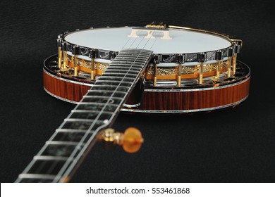 Mahogany banjo luxury gold inlaid with mother of pearl on a black background.