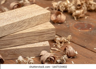 Mahogany wood block and wood shavings. Carpenter cabinet maker hand tools on the workbench.