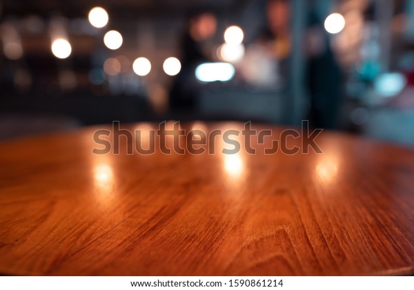 Mahogany wood\
table surface in warm luxury style cafe. Blur bokeh background with\
copy space for place display product.\
