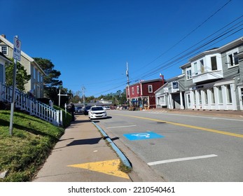 Mahone Bay NS, CAN, September 12, 2022 - The View Of The Main Street Through Mahone Bay, Nova Scotia On A Sunny Autumn Day. An Empty Handicap Parking Spot On The Street Is Ahead.