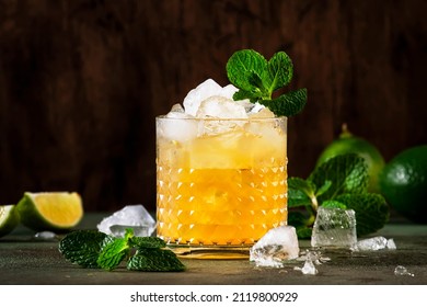 Mai Tai trendy alcoholic cocktail with rum, liqueur, syrup, lime juice, mint and crushed ice. Dark background, copy space