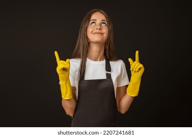 Maid In Black Apron And Gloves Points Up With Fingers