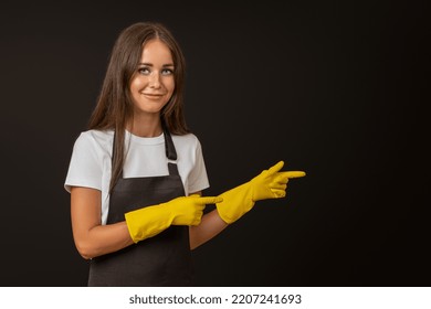 A Maid In A Black Apron And Gloves Points With Her Fingers At The Place For Text