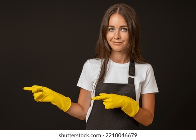 A Maid In A Black Apron And Gloves Points Her Fingers To The Side